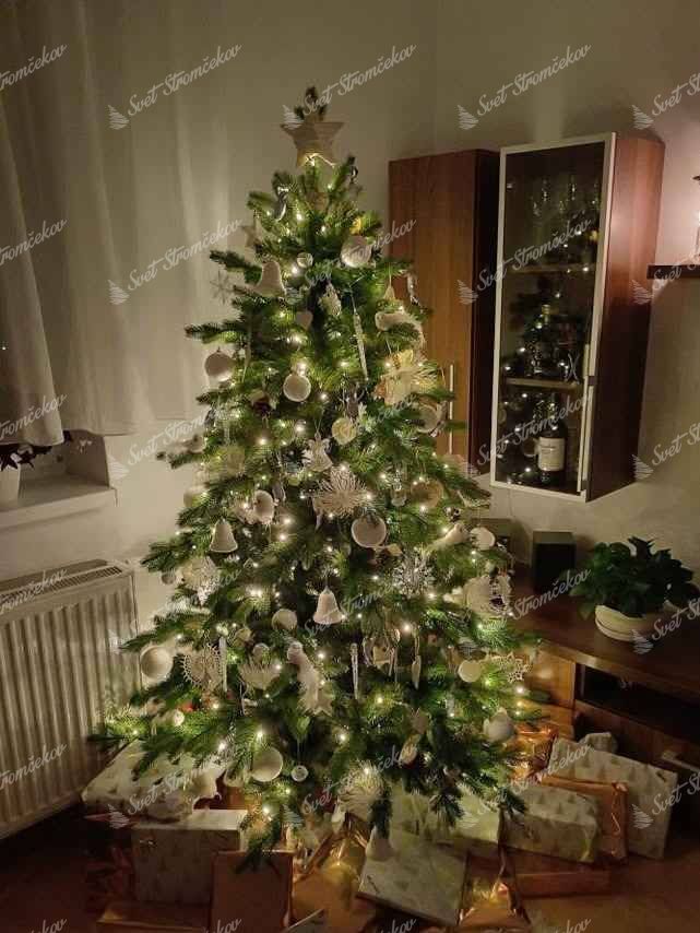 Umelý vianočný stromček 3D Smrek Exkluzívny 180cm. Stromček so zelenými vetvičkami je ozdobený rôznymi bielymi ozdobami.