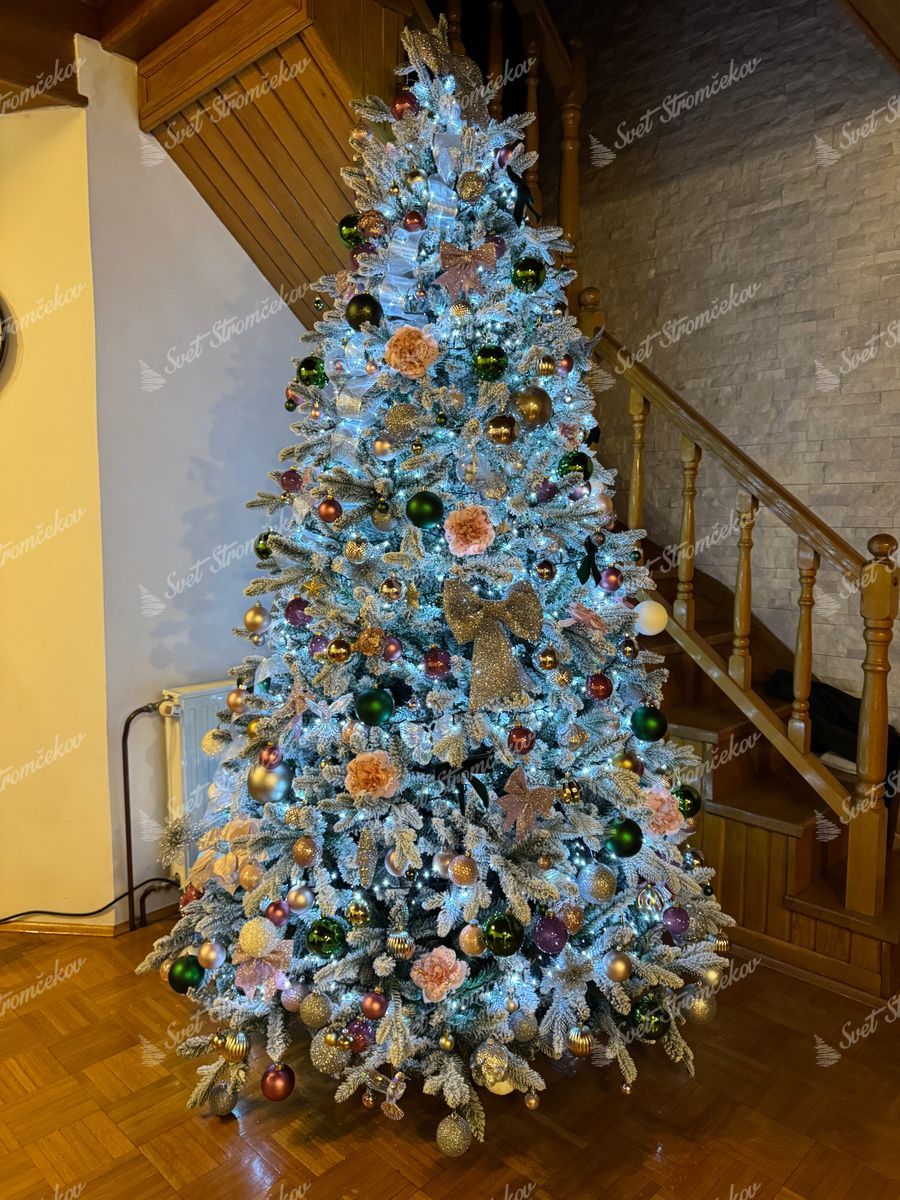 Umelý vianočný stromček 3D Smrek Kráľovský 240cm je husto ozdobený bielymi, ružovými a zelenými ozdobami.