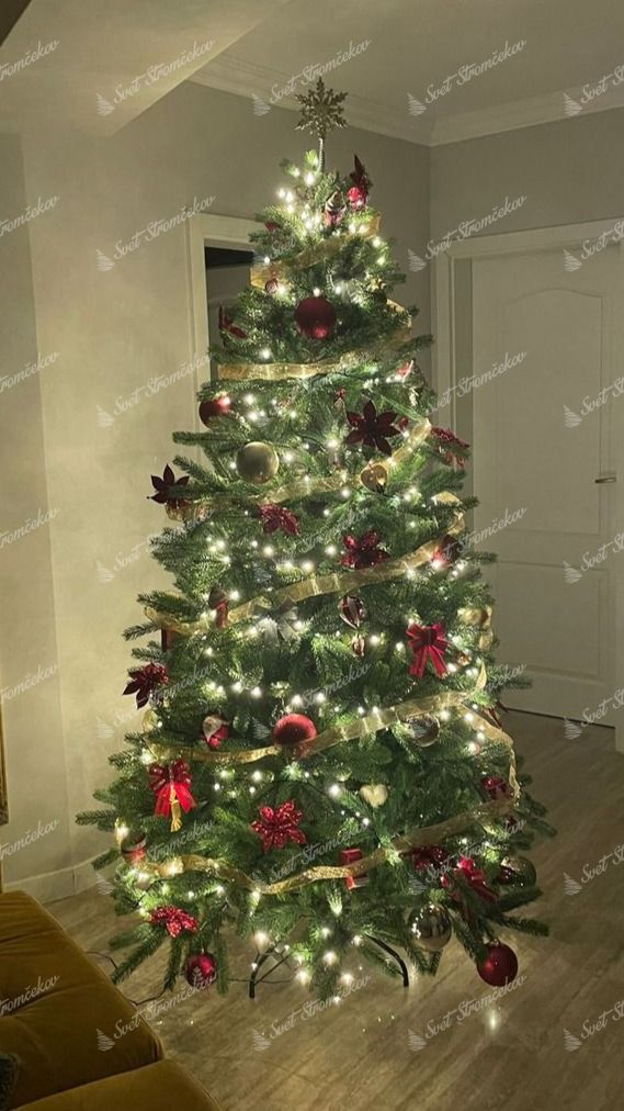 Umelý vianočný stromček FULL 3D Smrek Fínsky 210cm, stromček je ozdobený červenými a zlatými vianočnými guľami a zlatými stuhami.