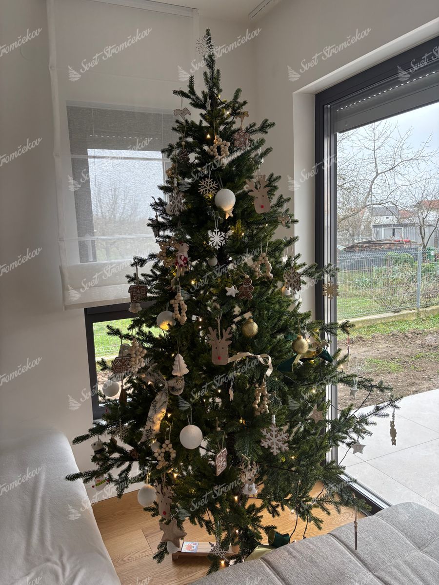 Umelý vianočný stromček FULL 3D Smrek Prírodný 210cm je ozdobený zlatými a bielmyi vianočnými guľami a drevenými dekoráciami.