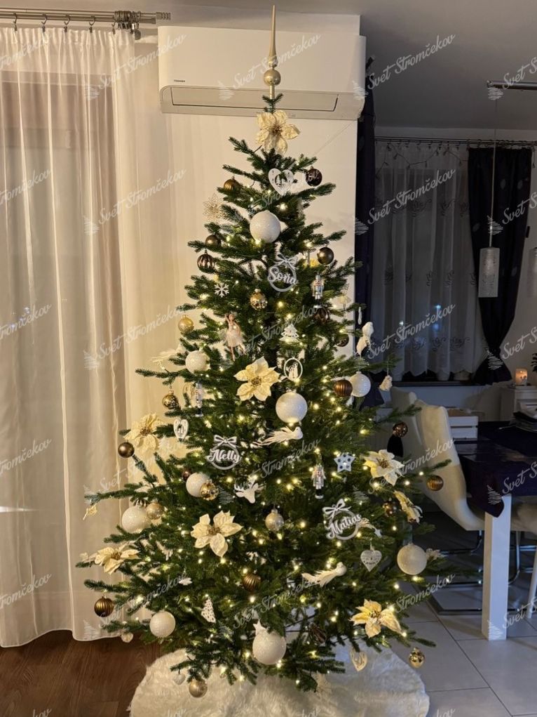 Umelý vianočný stromček FULL 3D Smrek Prírodný 210cm je ozdobený bieylmi a zlatými ozdobami.