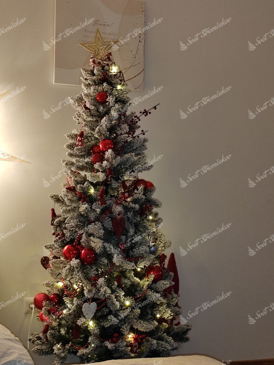 Umelý vianočný stromček Smrek Biely Úzky 180cm je ozdobený červenými a bielymi ozdobami a zlatou hviezdou.
