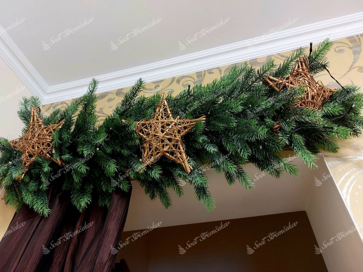 Vianočná girlanda 100% 3D Smrek Robustný 100cm nad dverami, ozdobená drevenými hviezdami.